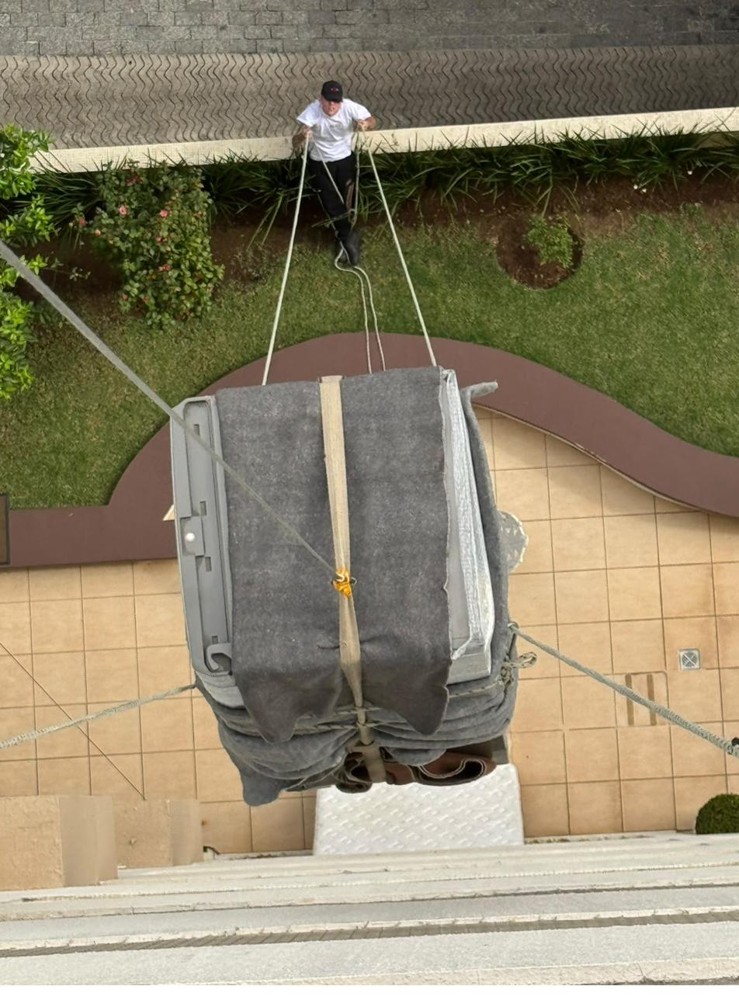 Içamento de colchões king size por fachada de prédio